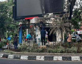 Driver ojek online bersama warga saat membersihkan puing pos polisi depan KBS pasca dibakar pendemo