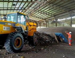 Proses pemindahan sampah basah hasil pencacahan ke tempat pengeringan yang akan diolah menjadi RDF dengan metode _biodrying_ di fasilitas pengolahan sampah menjadi bahan bakar alternatif di Kabupaten Cilacap, Jawa Tengah.